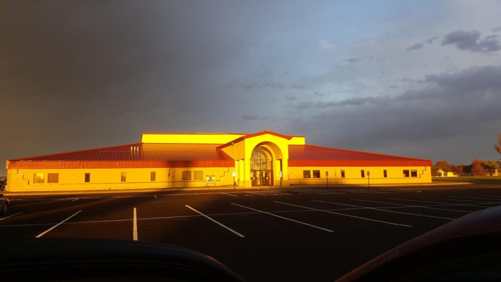 front of New Century Academy school building with sun shining brightly on it