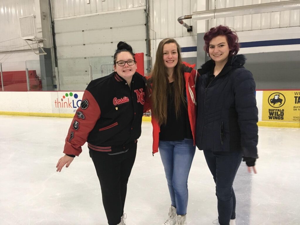 3 female students at an ice skating rink