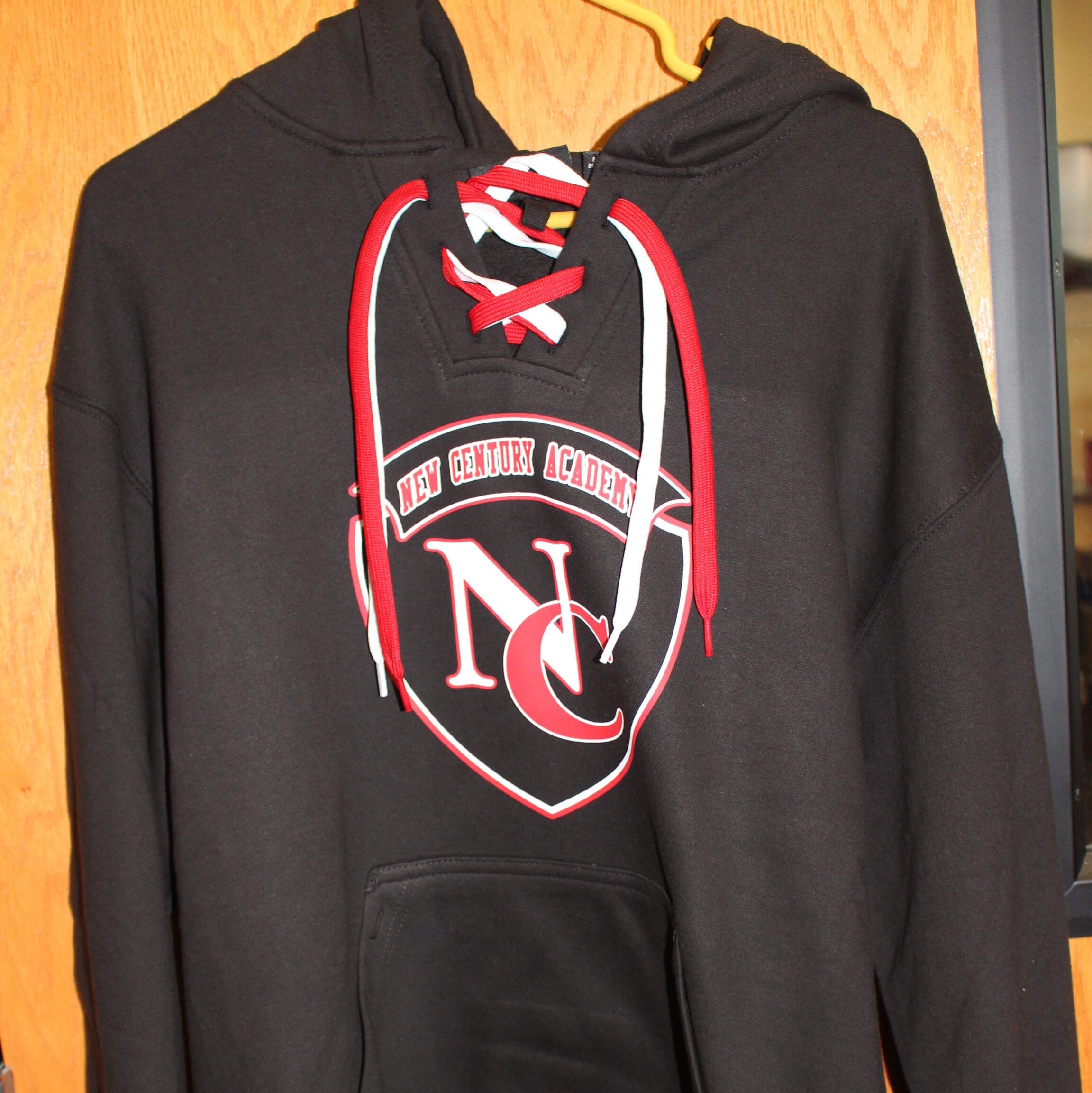 black hockey hoodie with the New Century Academy logo on it