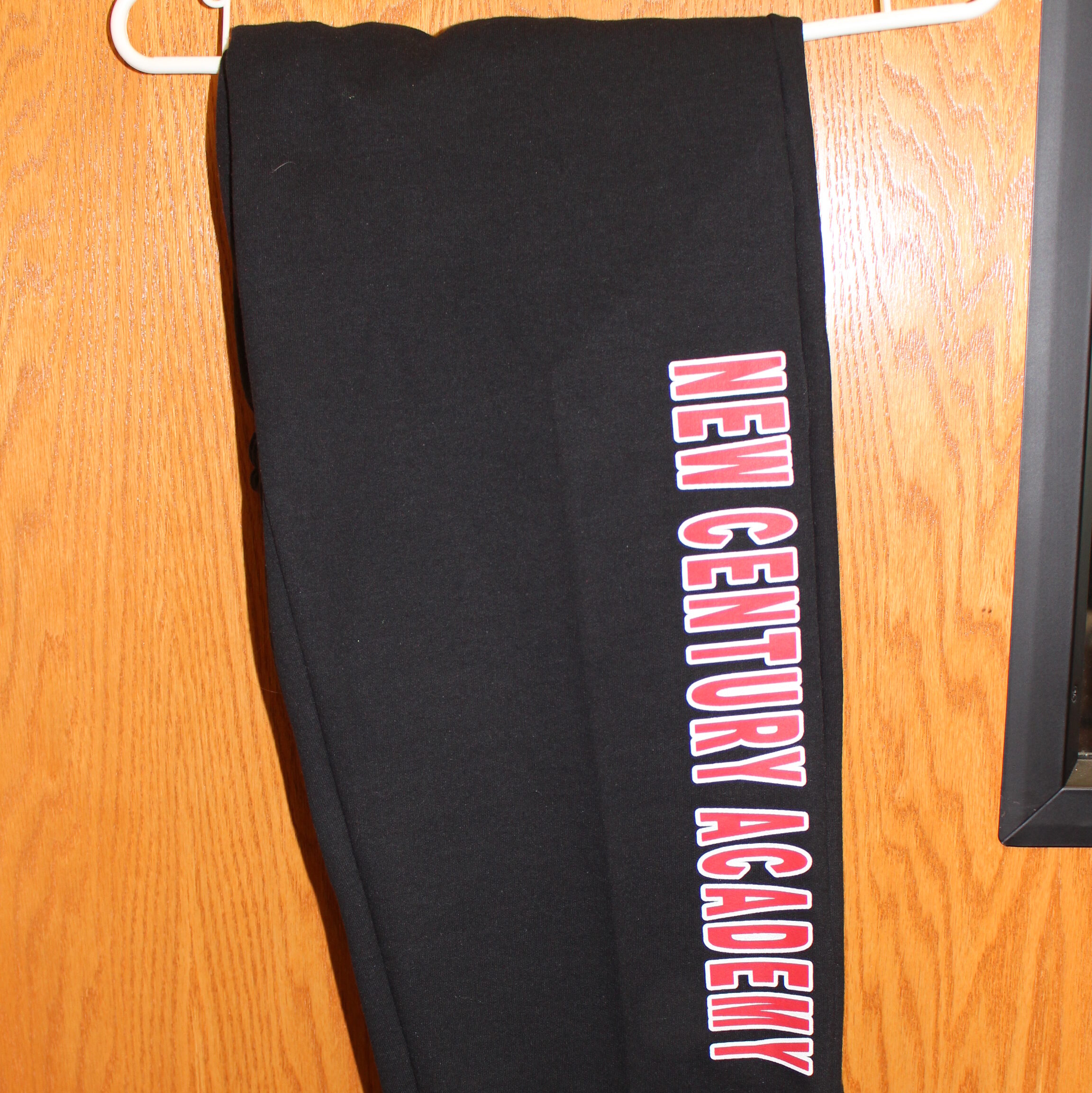 Black sweatpants with the words "New Century Academy" on them