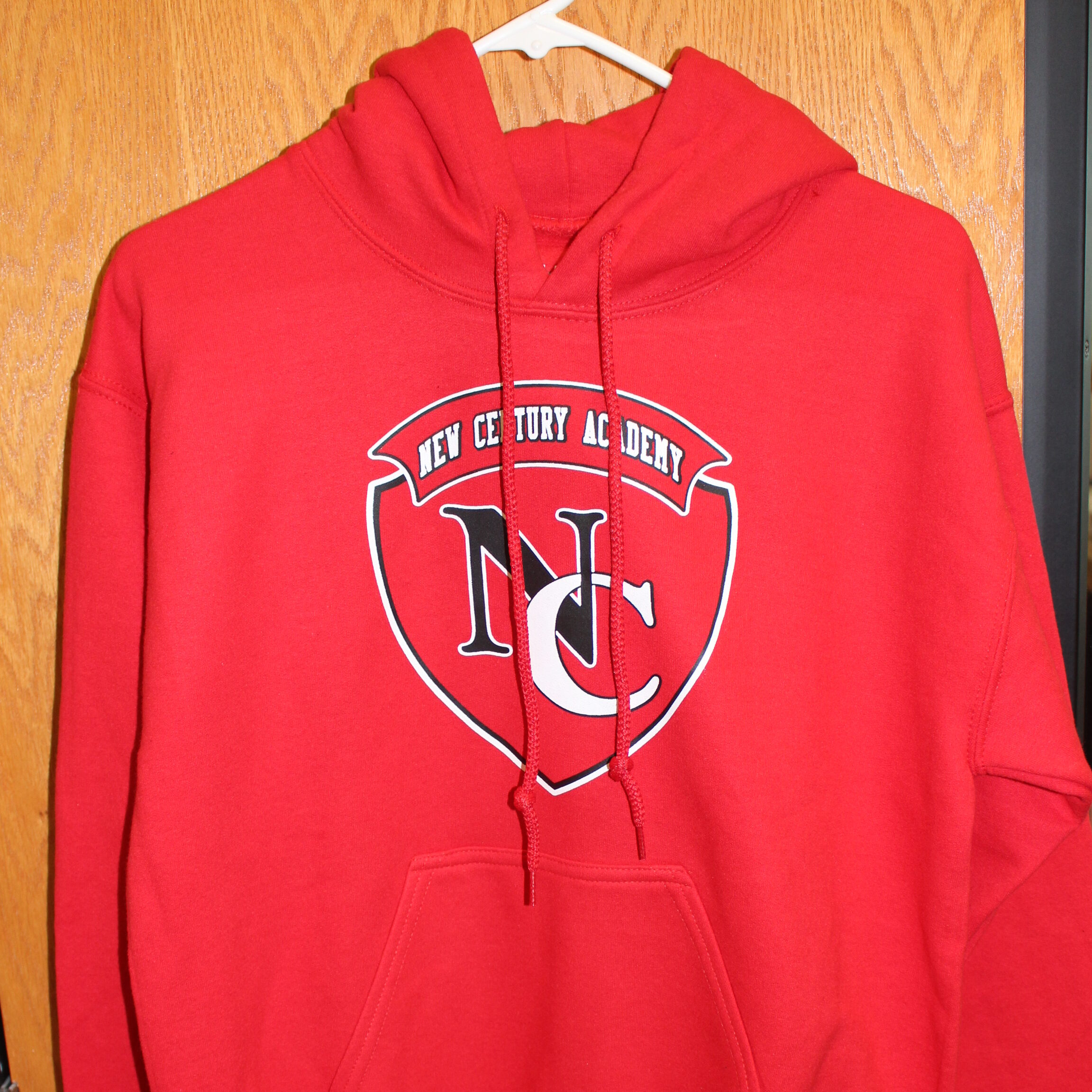 Red sweatshirt with the New Century Academy logo on it