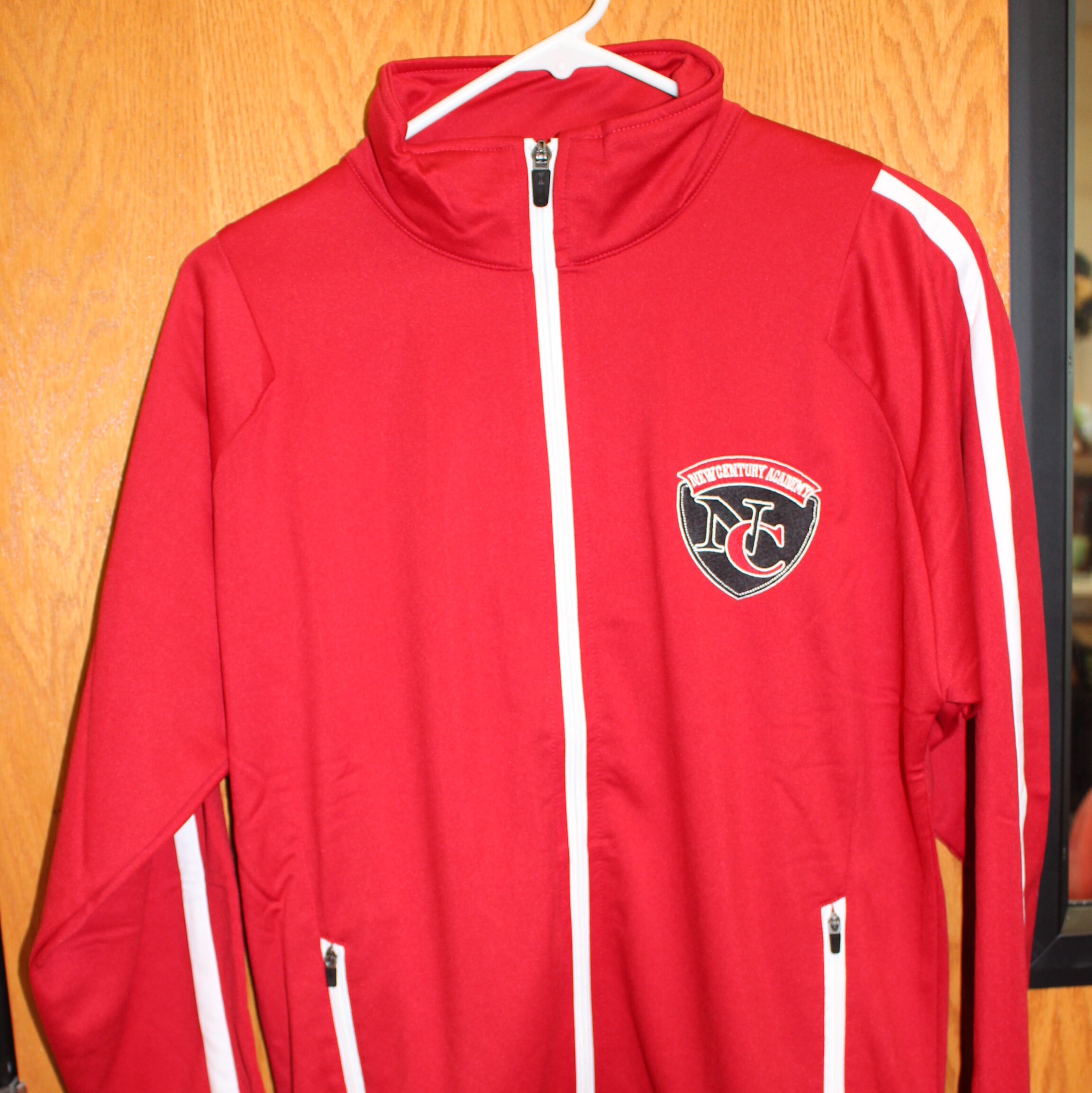 Red warm up jacket with the New Century Academy logo on it